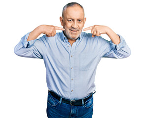 Fototapeta premium Senior man with grey hair and beard wearing casual blue shirt smiling cheerful showing and pointing with fingers teeth and mouth. dental health concept.