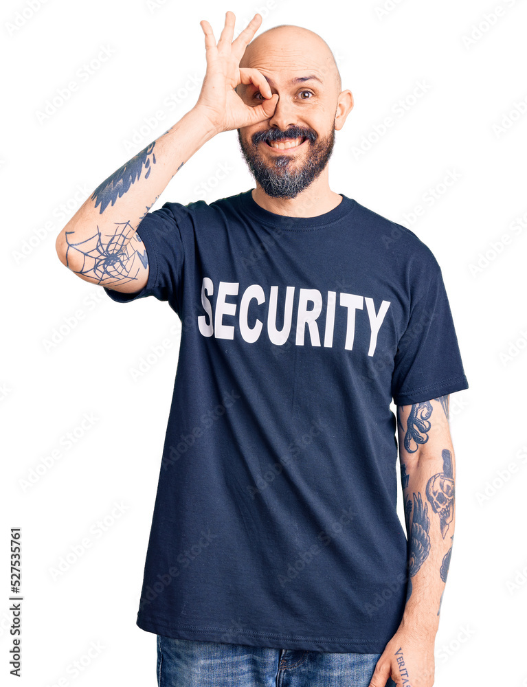 Poster Young handsome man wearing security t shirt doing ok gesture with hand smiling, eye looking through fingers with happy face.