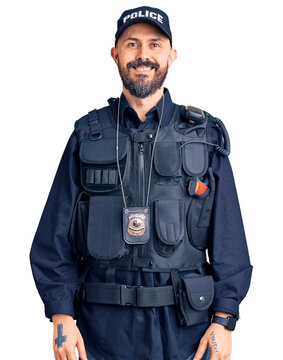 Young handsome man wearing police uniform with a happy and cool smile on face. lucky person.