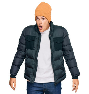 Handsome caucasian man wearing snow wear scared and amazed with open mouth for surprise, disbelief face
