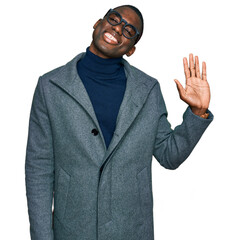 Young african american man wearing business clothes and glasses waiving saying hello happy and smiling, friendly welcome gesture