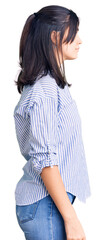 Young beautiful girl wearing striped shirt looking to side, relax profile pose with natural face with confident smile.