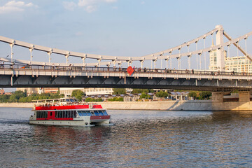 Fototapeta na wymiar MOSCOW, RUSSIA - August 25, 2022 : View of the Moskva River with a cruise boat in Moscow, Russia