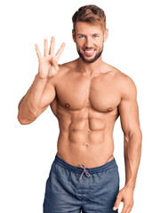Fototapeta premium Young caucasian man standing shirtless showing and pointing up with fingers number four while smiling confident and happy.