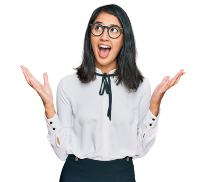Beautiful asian young woman wearing business shirt and glasses crazy and mad shouting and yelling with aggressive expression and arms raised. frustration concept.