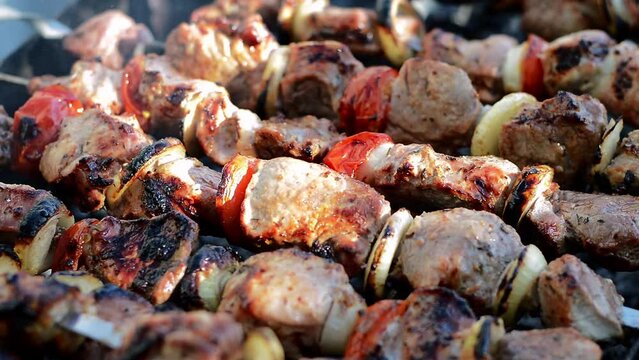 Fresh juicy hot kebab meat on iron skewers. Barbecue outdoors during summer time. Street food. Close-up