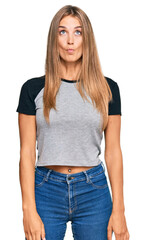 Fototapeta premium Young blonde woman wearing casual clothes making fish face with lips, crazy and comical gesture. funny expression.