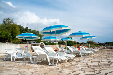 Fototapeta na wymiar Sun loungers on the beach in Europe. Sunny beaches of Croatia