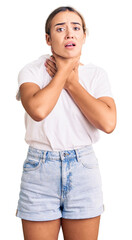 Young beautiful blonde woman wearing casual white tshirt shouting and suffocate because painful strangle. health problem. asphyxiate and suicide concept.