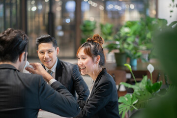 Young Business People Planning Marketing Plans at Coffee Shop. Teamwork Corporate Concept.	