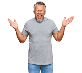 Middle age grey-haired man wearing casual clothes celebrating mad and crazy for success with arms raised and closed eyes screaming excited. winner concept