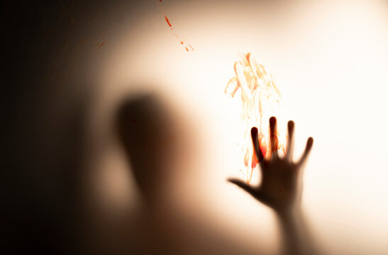 Shadowy figure hands behind glass - horror background