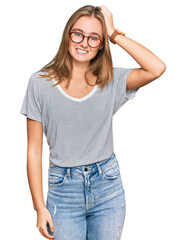 Obraz premium Beautiful young blonde woman wearing casual clothes and glasses confuse and wonder about question. uncertain with doubt, thinking with hand on head. pensive concept.