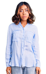 Young beautiful mixed race woman wearing casual business shirt with serious expression on face. simple and natural looking at the camera.