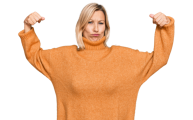 Middle age caucasian woman wearing casual winter sweater showing arms muscles smiling proud. fitness concept.