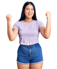Obraz na płótnie Canvas Young beautiful asian girl wearing casual clothes screaming proud, celebrating victory and success very excited with raised arms