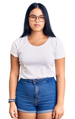 Obraz premium Young beautiful asian girl wearing casual clothes and glasses relaxed with serious expression on face. simple and natural looking at the camera.