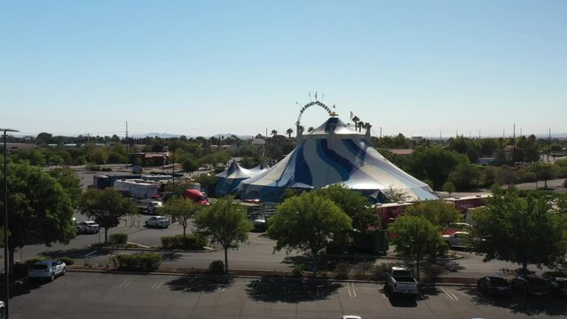 A big top circus tent set up in a parking lot in a small California town - aerial view