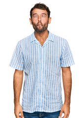 Obraz premium Handsome young man with beard wearing casual fresh shirt making fish face with lips, crazy and comical gesture. funny expression.
