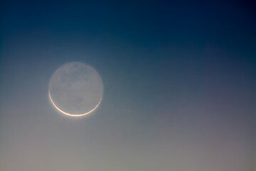Crescent moon showing earthshine at dawn