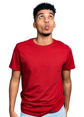 Obraz premium Young african american man wearing casual red t shirt making fish face with lips, crazy and comical gesture. funny expression.