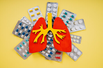 Lungs model with variation of pills on a yellow background