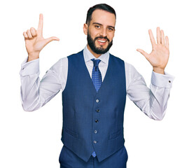 Young man with beard wearing business vest showing and pointing up with fingers number seven while smiling confident and happy.