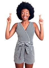 Young african american woman wearing casual clothes gesturing finger crossed smiling with hope and eyes closed. luck and superstitious concept.