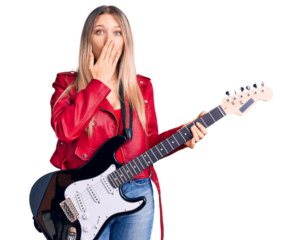 Young beautiful blonde woman playing electric guitar covering mouth with hand, shocked and afraid for mistake. surprised expression