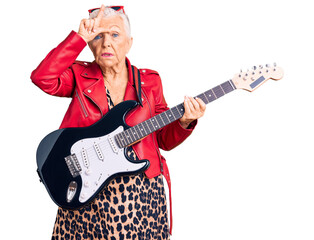Senior beautiful woman with blue eyes and grey hair wearing a modern look playing electric guitar...
