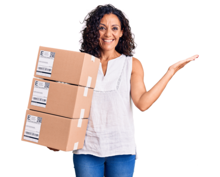 Middle age beautiful woman holding delivery package celebrating victory with happy smile and winner expression with raised hands