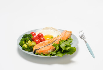 Plate with fried egg, salmon and vegetables on white background, concept of keto diet.