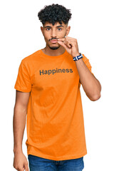 Young arab man wearing tshirt with happiness word message mouth and lips shut as zip with fingers. secret and silent, taboo talking