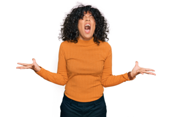 Young hispanic woman wearing casual clothes crazy and mad shouting and yelling with aggressive expression and arms raised. frustration concept.