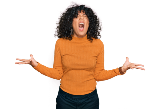 Young hispanic woman wearing casual clothes crazy and mad shouting and yelling with aggressive expression and arms raised. frustration concept.