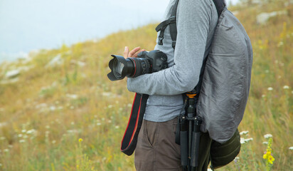 Photographer with backpack and digital camera in nature. Travel. Active lifestyle