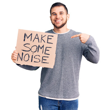Young handsome man holding make some noise banner pointing finger to one self smiling happy and proud