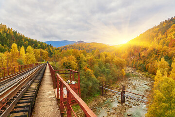 Fototapeta premium View on railway bridge above the Prut river. Beauteful autumn in Carpathian mountains, Ukraine