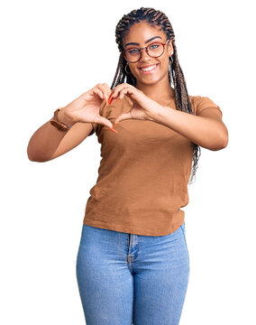 Young african american woman with braids wearing casual clothes and glasses smiling in love showing heart symbol and shape with hands. romantic concept.