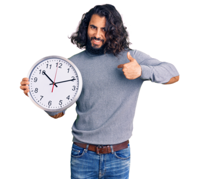 Young arab man holding big clock pointing finger to one self smiling happy and proud