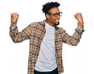 Young african american man with beard wearing casual clothes and glasses very happy and excited doing winner gesture with arms raised, smiling and screaming for success. celebration concept.