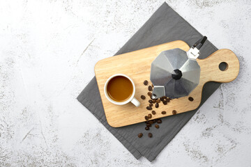 Coffee cup with moka pot and wooden tray on texture background.