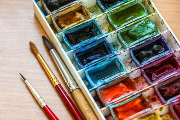 Top view of paintbrushes palette and watercolor paints