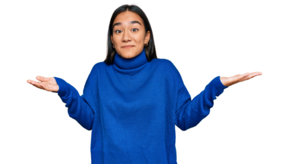 Young asian woman wearing casual winter sweater clueless and confused expression with arms and hands raised. doubt concept.