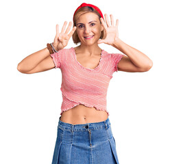 Obraz na płótnie Canvas Young blonde woman wearing casual clothes and diadem showing and pointing up with fingers number nine while smiling confident and happy.
