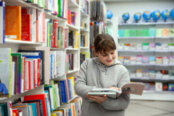 12-year-old girl between bookshelves in store