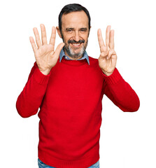 Middle age hispanic man wearing casual clothes showing and pointing up with fingers number eight while smiling confident and happy.