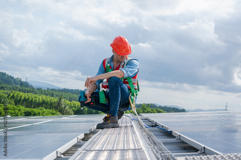 Aufkleber technician wearing safety harness belt using drill during installing the solar panels on roof struct
