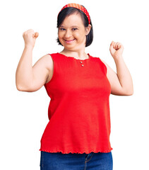 Brunette woman with down syndrome wearing casual clothes screaming proud, celebrating victory and...