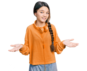 Young brunette girl with long hair wearing sweatshirt and headphones clueless and confused expression with arms and hands raised. doubt concept.